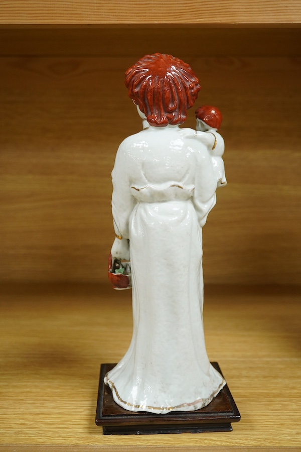 A Chinese porcelain group, mother and child on stand, Republic period, 29cm high. Condition - the collar of the garment and contents of basket both broken.